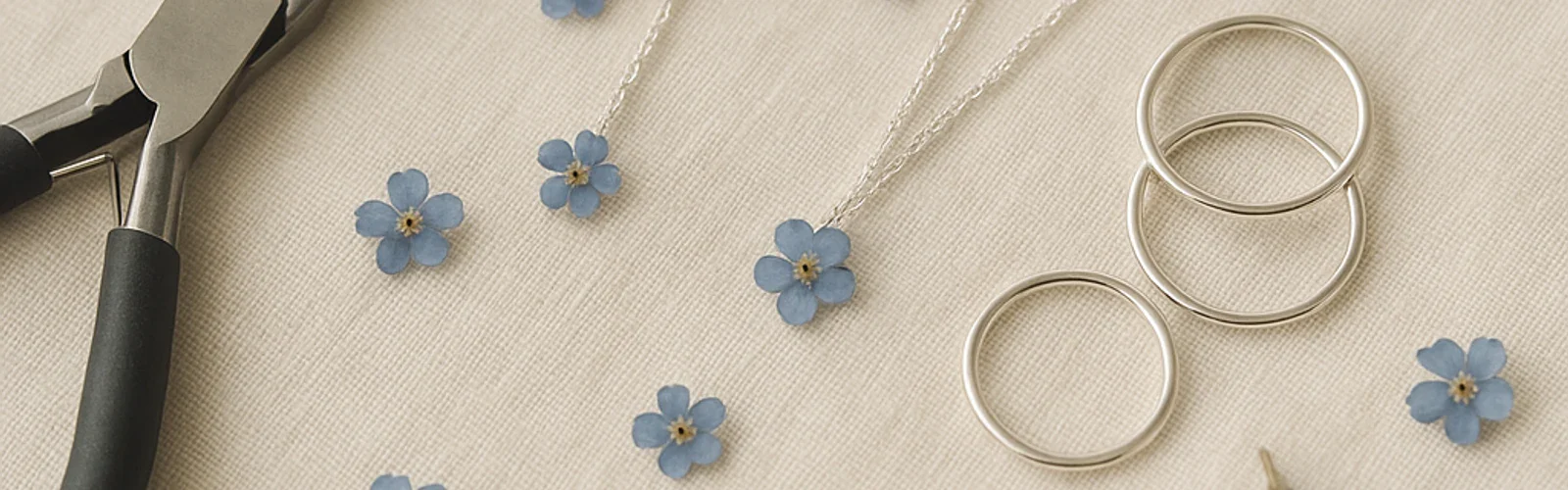 Sfeerbeeld: zilveren sieraden en gedroogde bloemen (conceptbeeld)